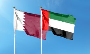 Qatar,Flag,And,United,Arab,Emirates,Flag,On,Cloudy,Sky.
